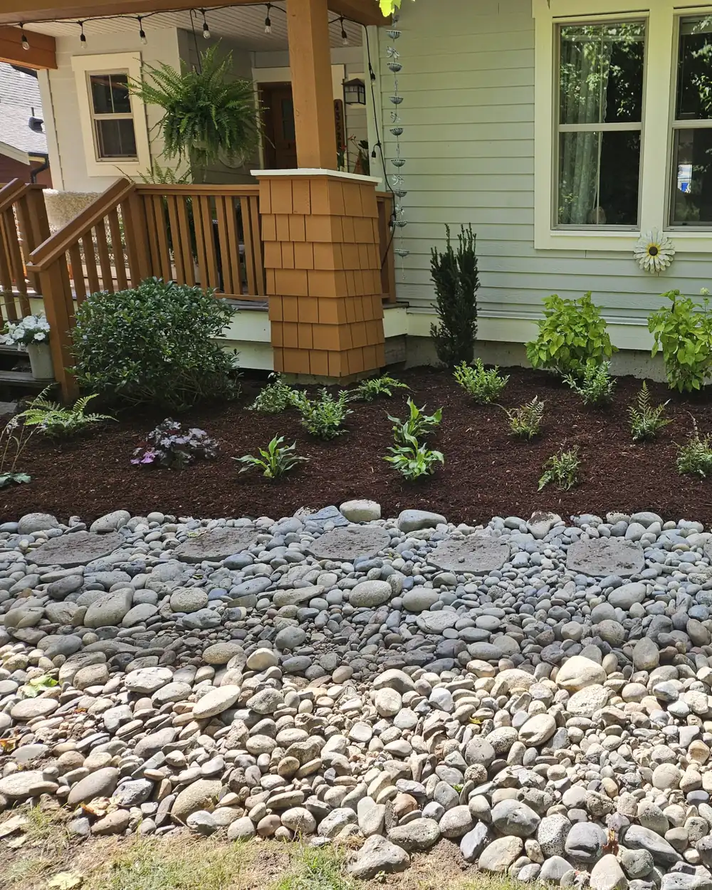 Cedar porch posts above a mulched bed of new plantings, edged with river rock — landscaping by Blades Landscaping, Chilliwack